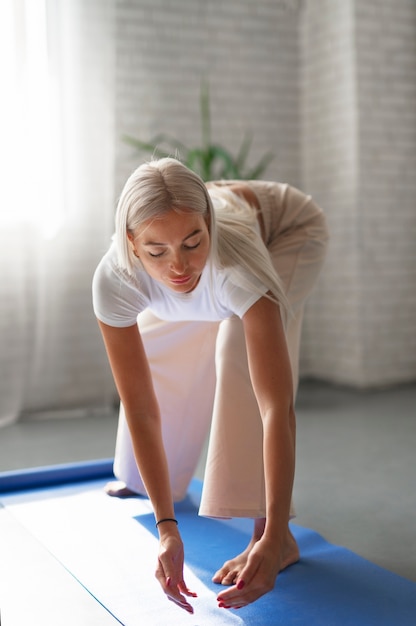 Bezpłatne zdjęcie pełne ujęcie kobiety ćwiczącej tai chi w pomieszczeniu