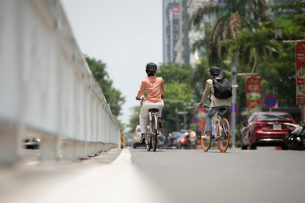 Pełne ujęcie ludzi idących do pracy na rowerze