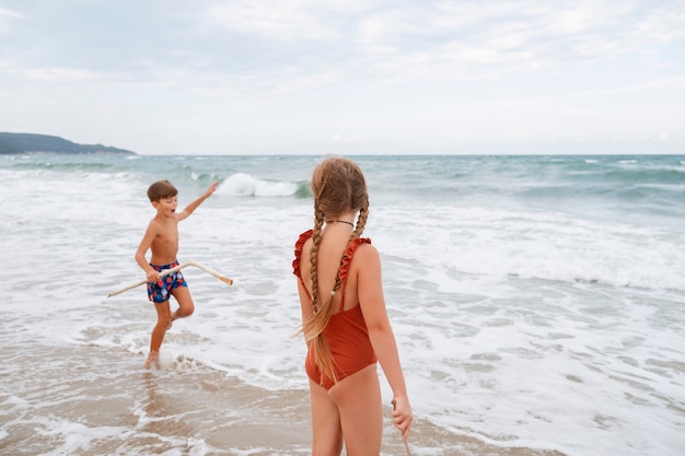 Pełne ujęcie małych dzieci bawiących się na plaży