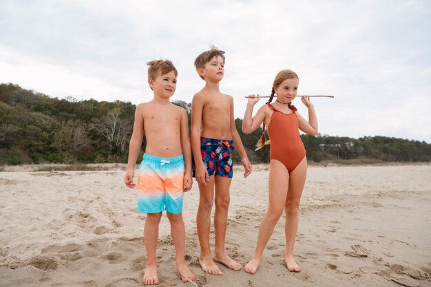 Pełne ujęcie małych dzieci bawiących się na plaży