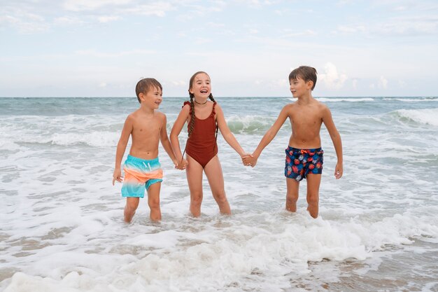 Pełne ujęcie małych dzieci bawiących się na plaży