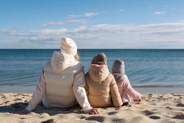 Pełne ujęcie matki i dzieci na plaży