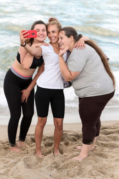 Pełne ujęcie przyjaciół fitness biorących selfie