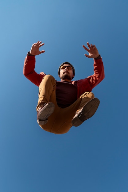 Bezpłatne zdjęcie pełne ujęcie sprawnego mężczyzny skaczącego na zewnątrz
