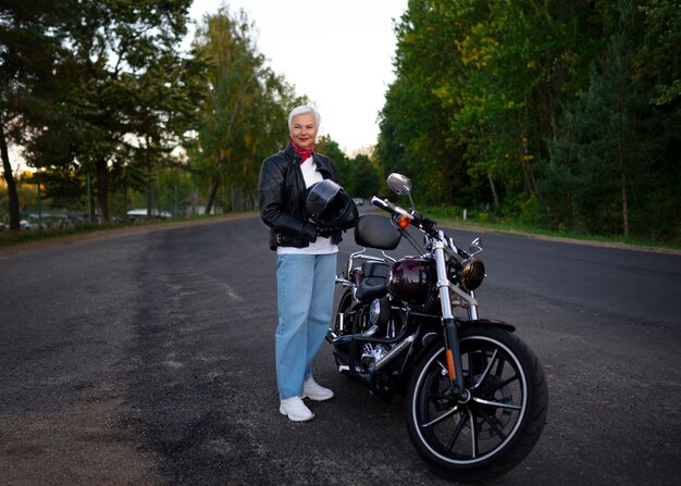 Bezpłatne zdjęcie pełne ujęcie starszej kobiety z motocyklem