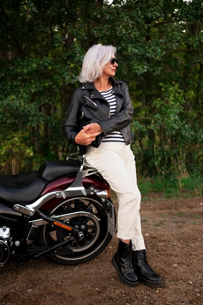 Pełne ujęcie starszej kobiety z motocyklem