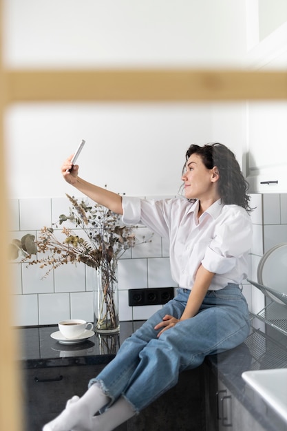 Pełne zdjęcie kobiety biorącej selfie