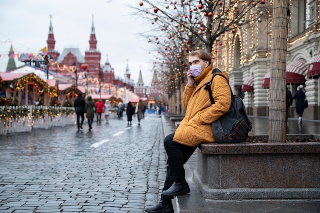 Bezpłatne zdjęcie pełny strzał mężczyzna noszący maskę w mieście