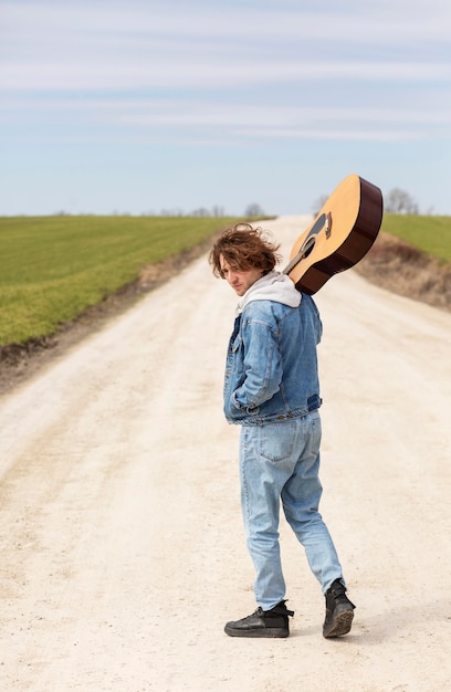 Bezpłatne zdjęcie pełny strzał mężczyzna trzyma gitarę