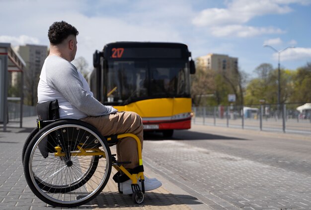 Pełny strzał niepełnosprawny mężczyzna czeka na autobus