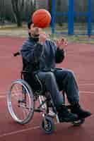 Bezpłatne zdjęcie pełny strzał niepełnosprawny mężczyzna grający w koszykówkę