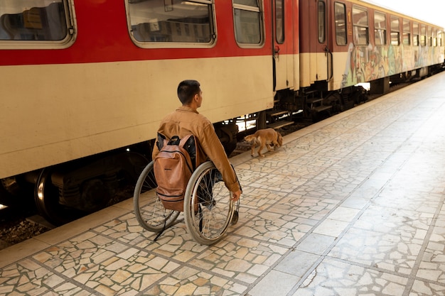 Bezpłatne zdjęcie pełny strzał niepełnosprawny mężczyzna na stacji kolejowej