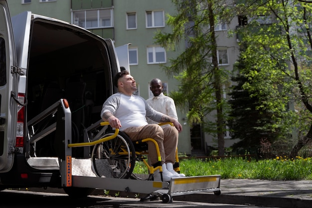 Pełny strzał niepełnosprawny mężczyzna wysiadający z samochodu