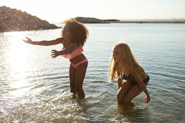 Pełny strzał uśmiechniętych przyjaciół na plaży?