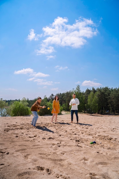 Pełny strzał znajomych grających w grę na plaży