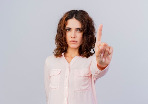 Bezpłatne zdjęcie pewna siebie młoda kobieta kaukaska pokazuje palec wskazujący