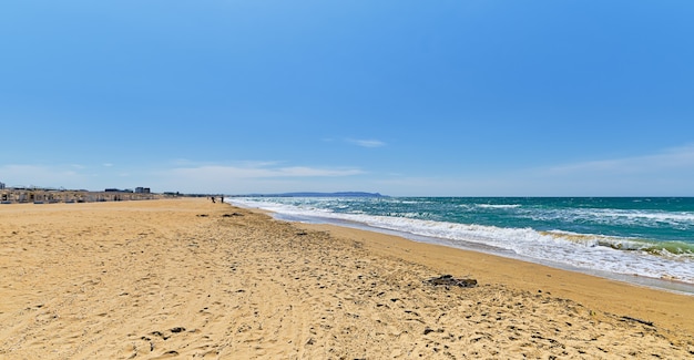 Piaszczysta dzika plaża, błękitne morze z chmurami i błękitne niebo rozmazuje się i filtruje na wybrzeżu. Piękny niebieski ocean przyrody na świeżym powietrzu,