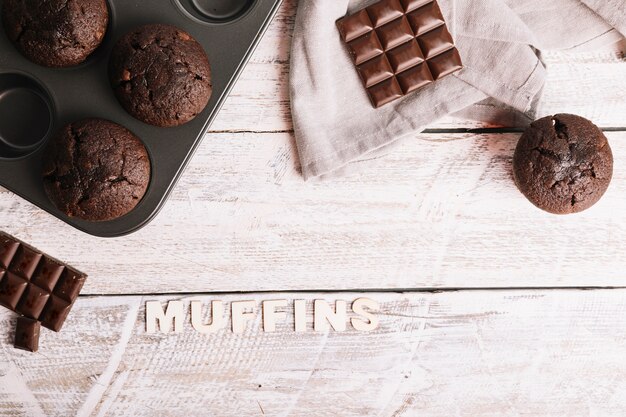 Piec muffins z tekstem na bielu stole