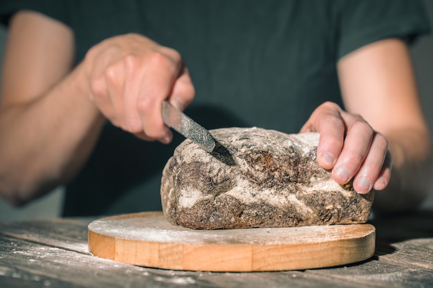 Bezpłatne zdjęcie piekarz trzymający w rękach świeży chleb