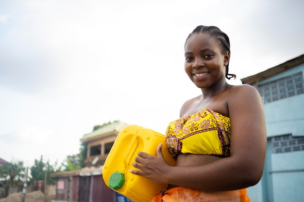 Piękna afrykańska kobieta trzymająca odbiorcę wody