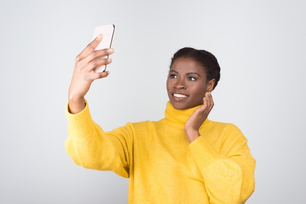 Piękna amerykanin afrykańskiego pochodzenia kobieta bierze selfie z smartphone