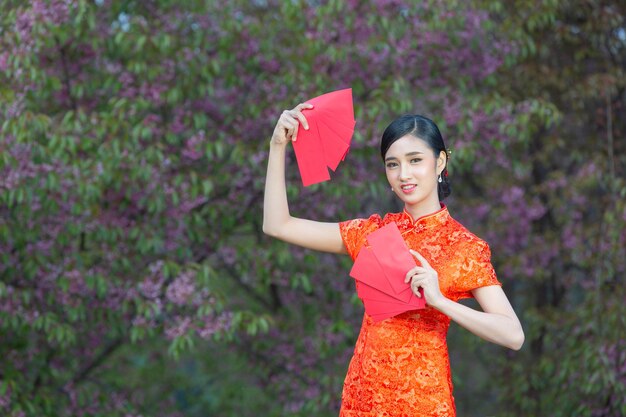 Piękna Azjatka pokazuje coś i bierze czerwone koperty w chiński nowy rok