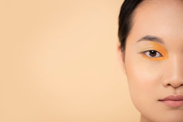 Bezpłatne zdjęcie piękna azjatycka kobieta ubrana w pomarańczowy cień do powiek