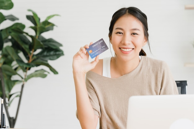 Piękna Azjatycka kobieta używa komputer lub laptop kupuje online zakupy