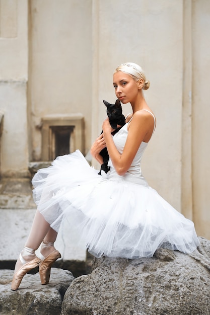 Bezpłatne zdjęcie piękna baletnica pieszcząca czarnego kota