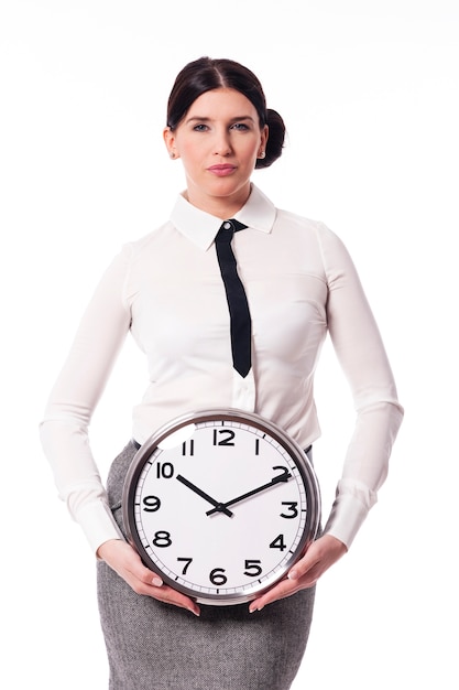 Piękna bizneswoman trzyma zegar