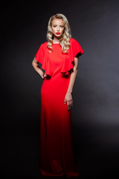 Piękna blondynki kobieta w czerwonej wieczór sukni