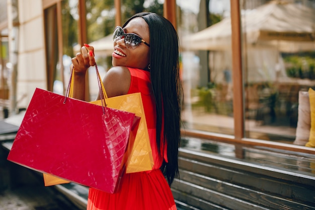 Piękna czarna dziewczyna z torba na zakupy w mieście