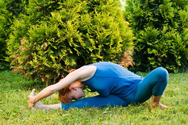 Piękna czerwona kobieta robi fitness lub ćwiczeń jogi