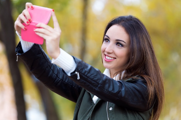 Piękna dziewczyna biorąc a selfie jesienią.