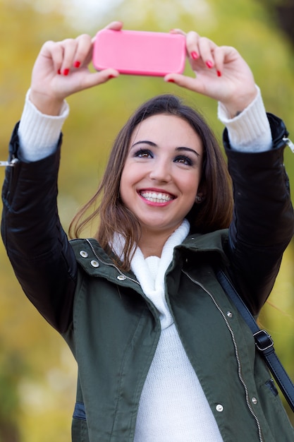 Piękna dziewczyna biorąc a selfie jesienią.