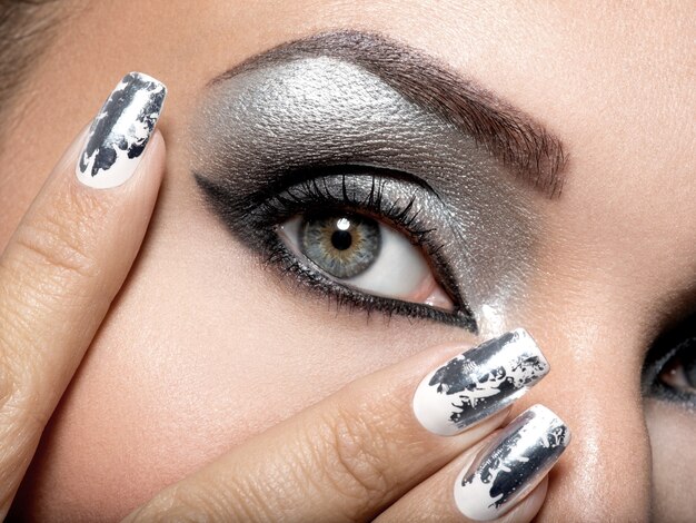 Bezpłatne zdjęcie piękna dziewczyna o srebrnym makijażu oczu i metalowych paznokciach.