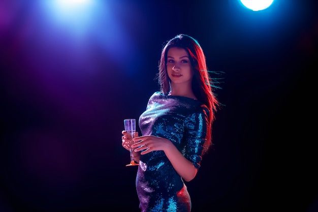 Piękna dziewczyna tańczy na imprezie pijąc szampana