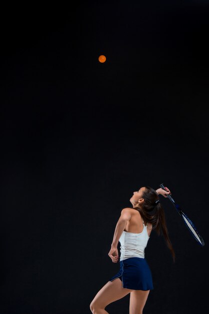 piękna dziewczyna tenisista z rakietą na ciemnym tle