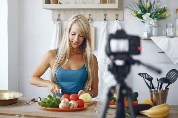 Piękna i sportowa dziewczyna nagrywa wideo w kuchni