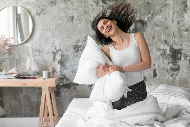 Bezpłatne zdjęcie piękna kobieta bawić się z poduszką