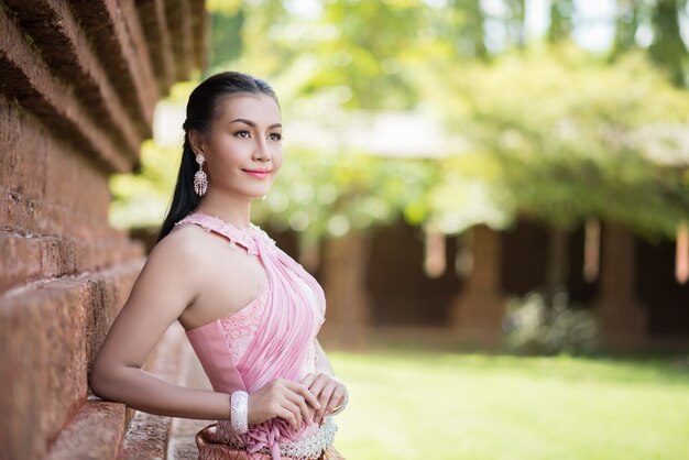 Piękna kobieta jest ubranym typową Tajlandzką suknię