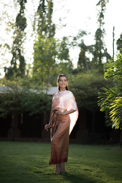 Piękna kobieta jest ubranym typową Tajlandzką suknię