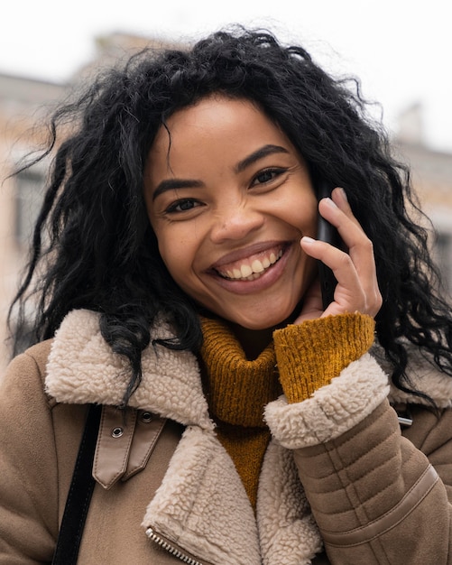 Bezpłatne zdjęcie piękna kobieta rozmawia przez telefon na zewnątrz