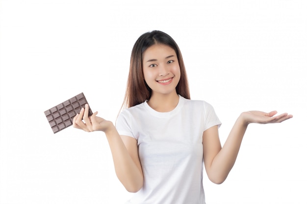 Piękna kobieta trzyma rękę czekoladę z szczęśliwym uśmiechem