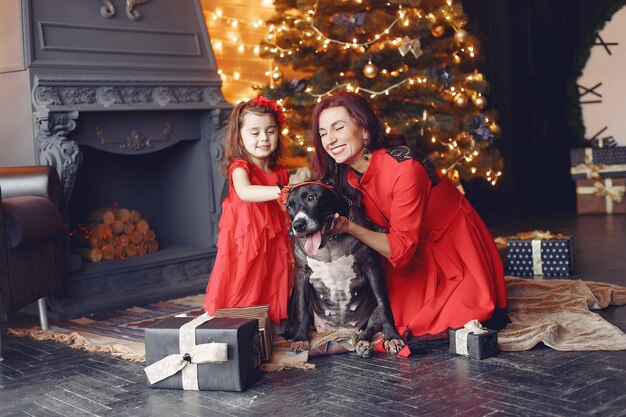 Piękna kobieta w czerwonej sukience. Rodzina w domu. Matka z córką. Ludzie z psem.