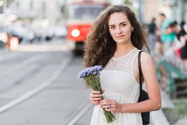 Piękna kobieta z kwiatami na ulicie