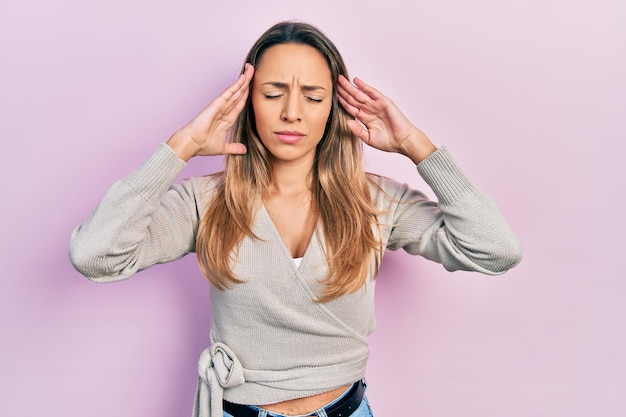 Bezpłatne zdjęcie piękna latynoska kobieta ubrana w luźny sweter z ręką na głowie, ból głowy z powodu stresu. cierpiący na migrenę.