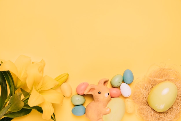 Piękna leluja kwitnie z Easter jajkami i gniazdeczkiem na żółtym tle