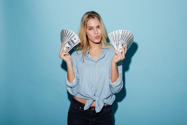 Bezpłatne zdjęcie piękna młoda blondynki kobieta trzyma pieniądze w rękach
