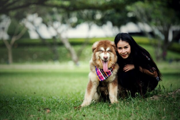 Piękna młoda kobieta bawić się z jej małym psem w parku outdoors. Portret stylu życia.
